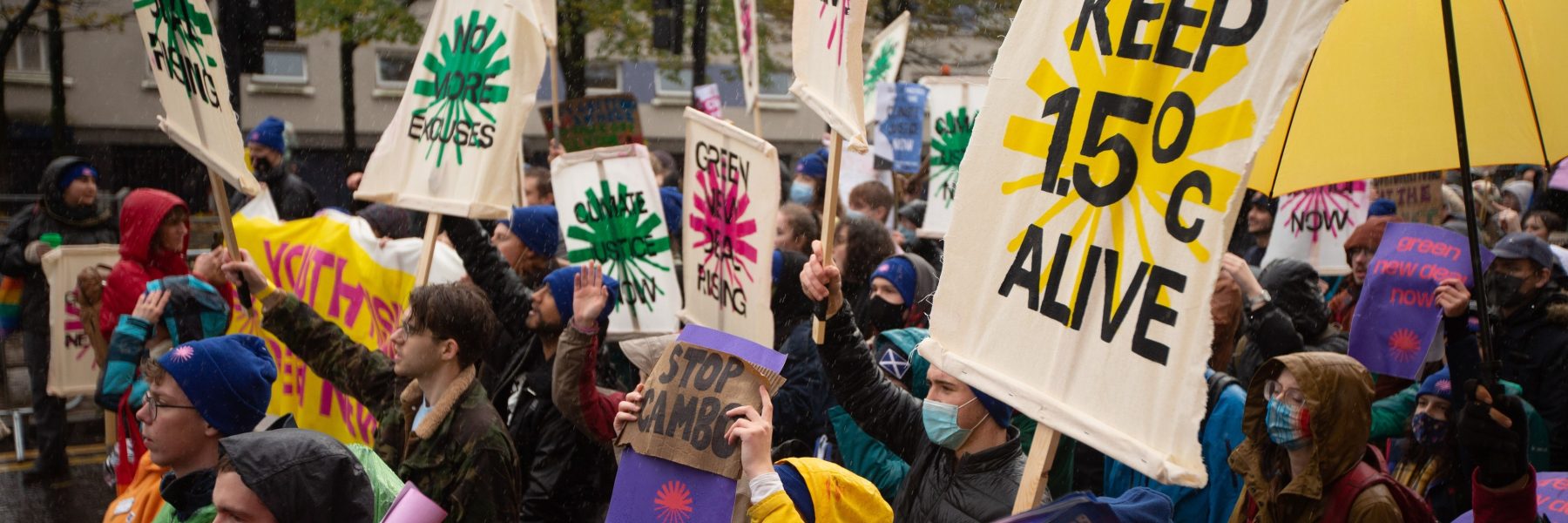 Climate activists carrying signs at a protest in Glasgow